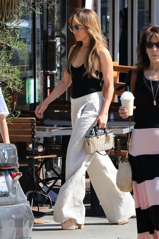 Jennifer Lopez walks in Los Angeles on August 5 wearing a black tank top and linen pants by St Agni, Meghan Markle's favorite brand