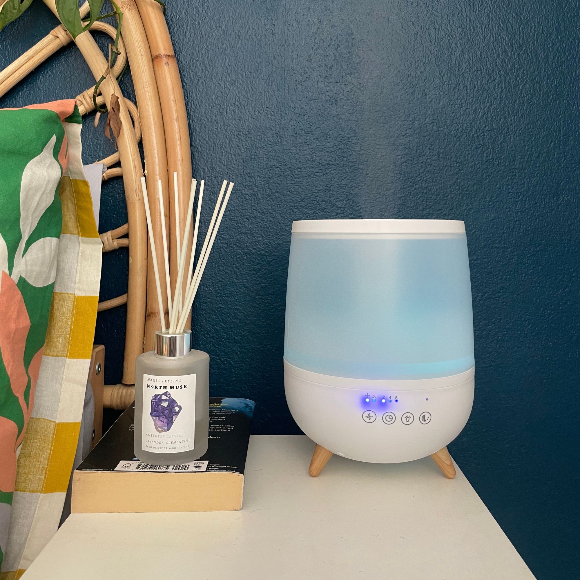 Dunelm humidifier sitting on white bedside table, next to a book and reed diffuser
