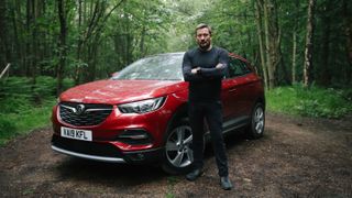 How to stay calm under pressure: SAS Who Dares Wins star Ollie Ollerton stands next to the Vauxhall Grandland X SUV in red, which is parked in the middle of a forest