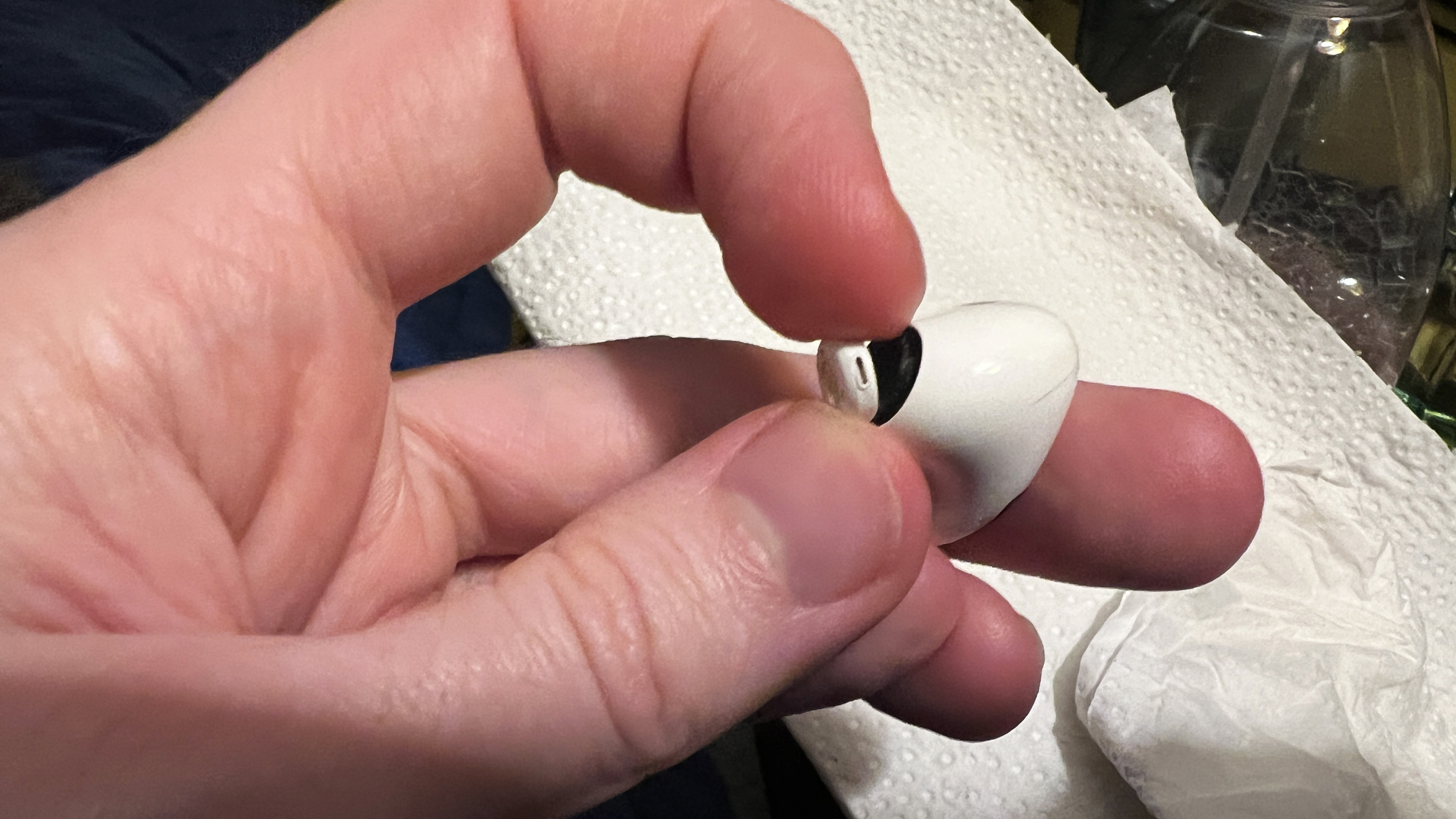A man prises an AirPods Pro 2 tip connector away from the earbud