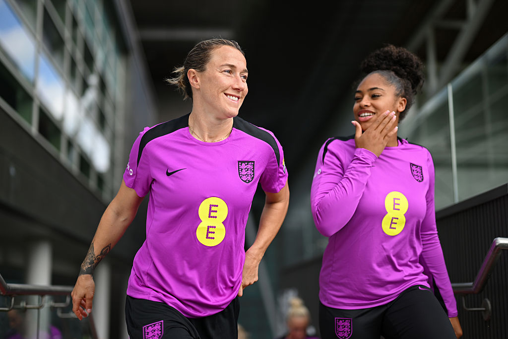 Lucy Bronze and Khiara Keating of England walk out prior to a training session at St Georges Park on June 16, 2025 in Burton-upon-Trent, England.