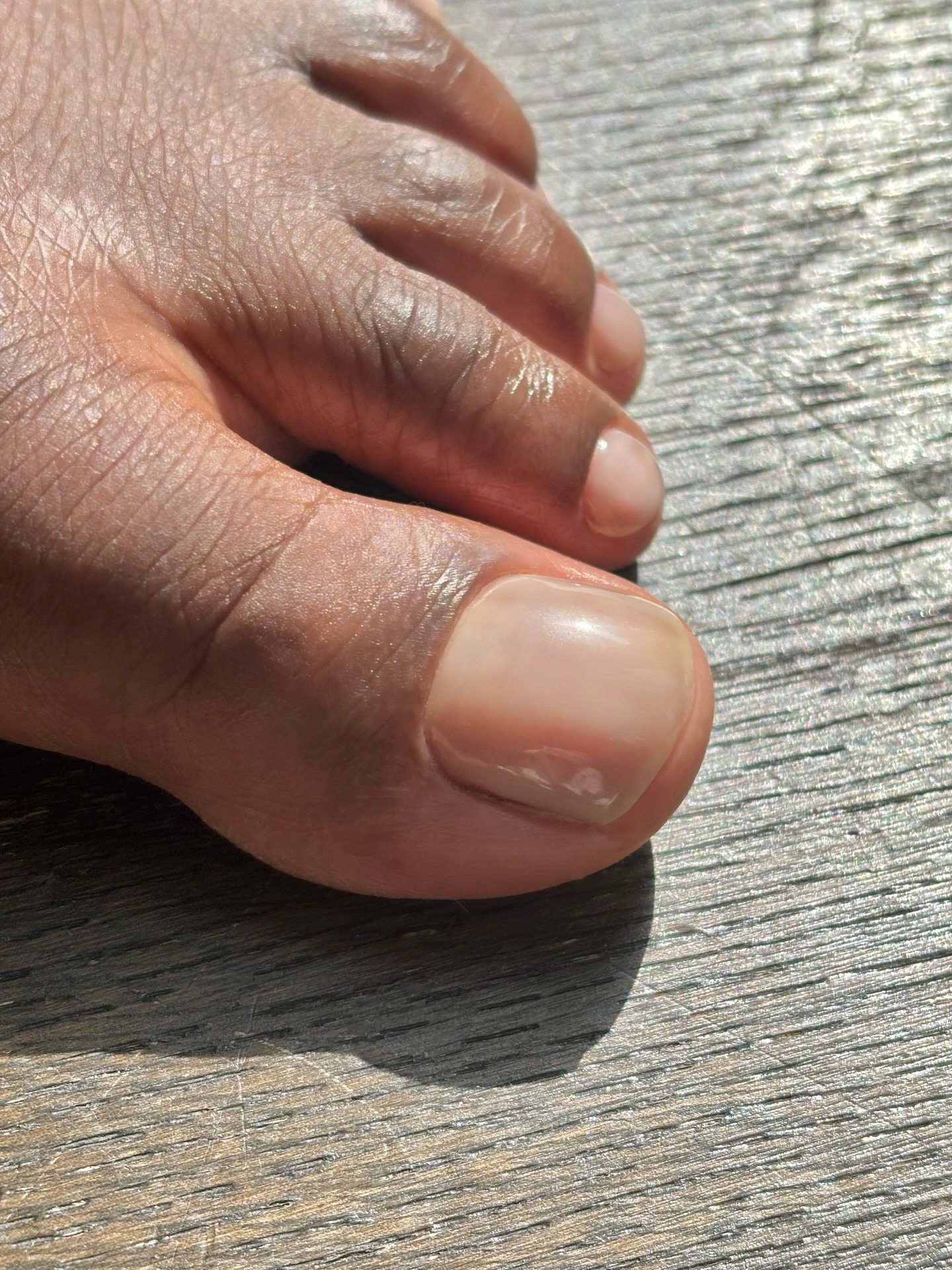 A close-up of a short, super sheer pedicure
