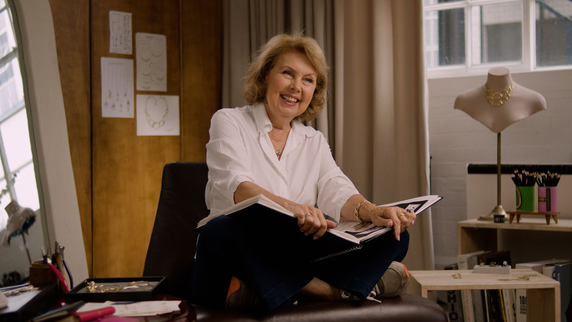 jewellery designer dinny hall sits on her desk