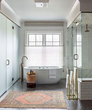 Bathroom with large windows and herringbone patterned floor tiles