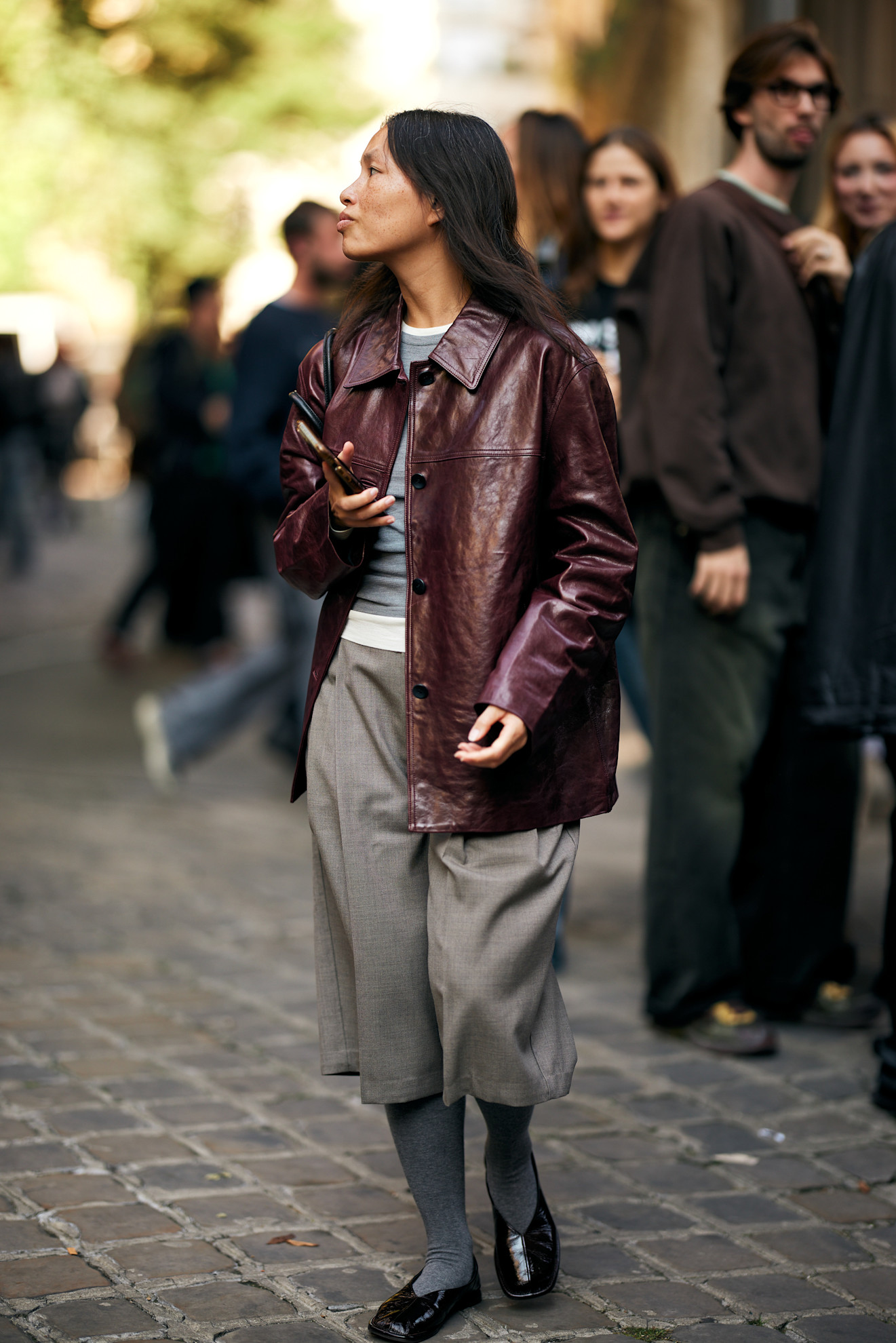 woman wearing leather jacket, bermuda shorts, and flats