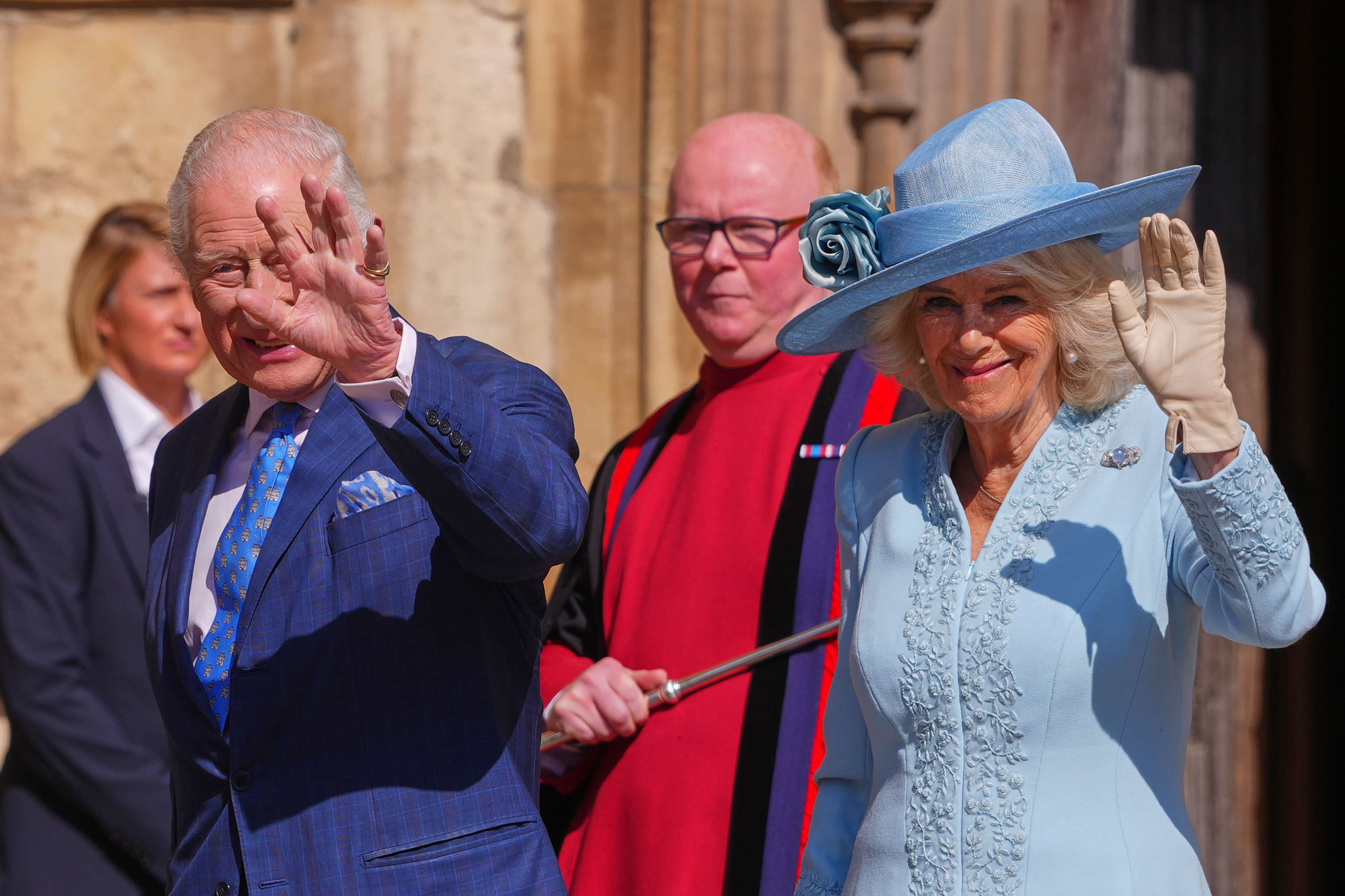 King Charles and Queen Camilla waving in blue outfits on Easter 2025