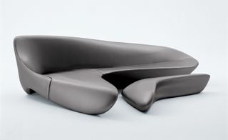 Grey curved sofa with pouf