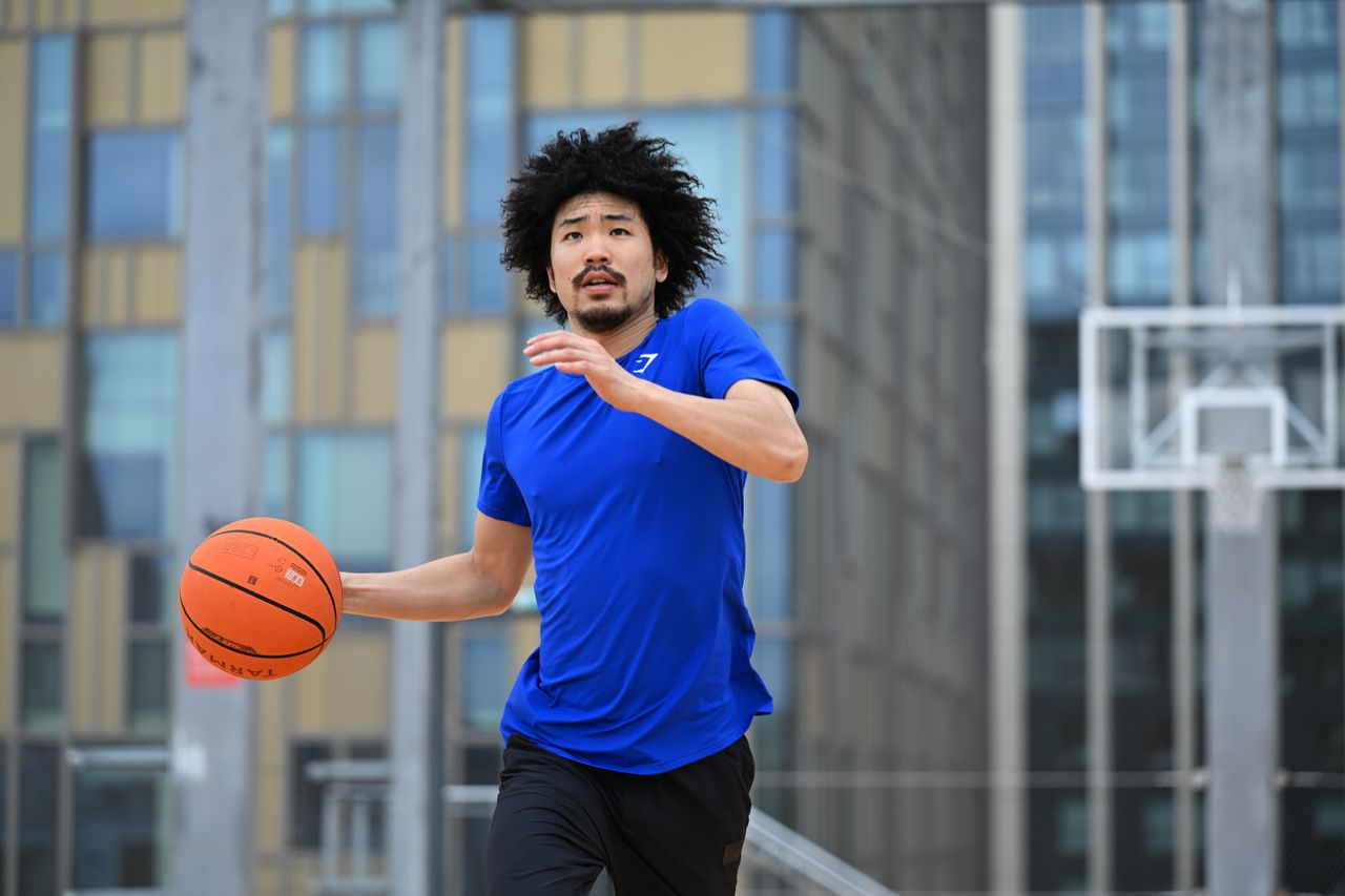 Person in playing basketball on a rooftop basketball court