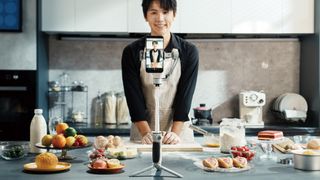 Zhiyun Cinepeer CQ5 Smartphone Stabilizer standing on its tripod legs, while being used by a person in a kitchen