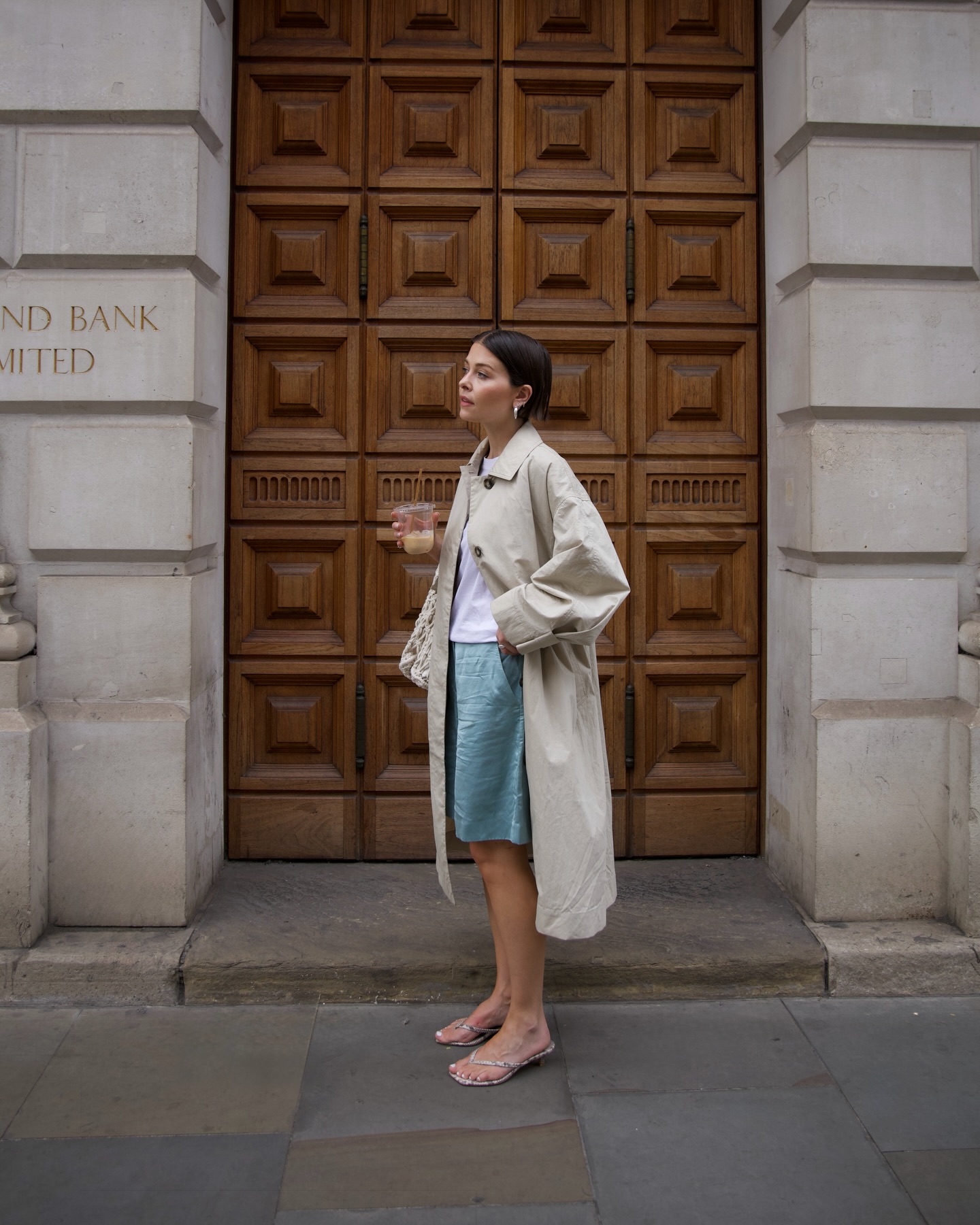 An image of @thealiceedit wearing heeled flip-flops with a white t-shirt and silk taffeta shorts.