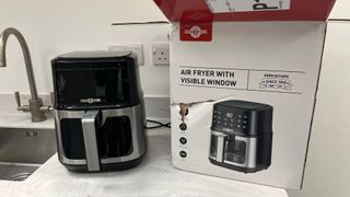 An air fryer with its box on a kitchen countertop