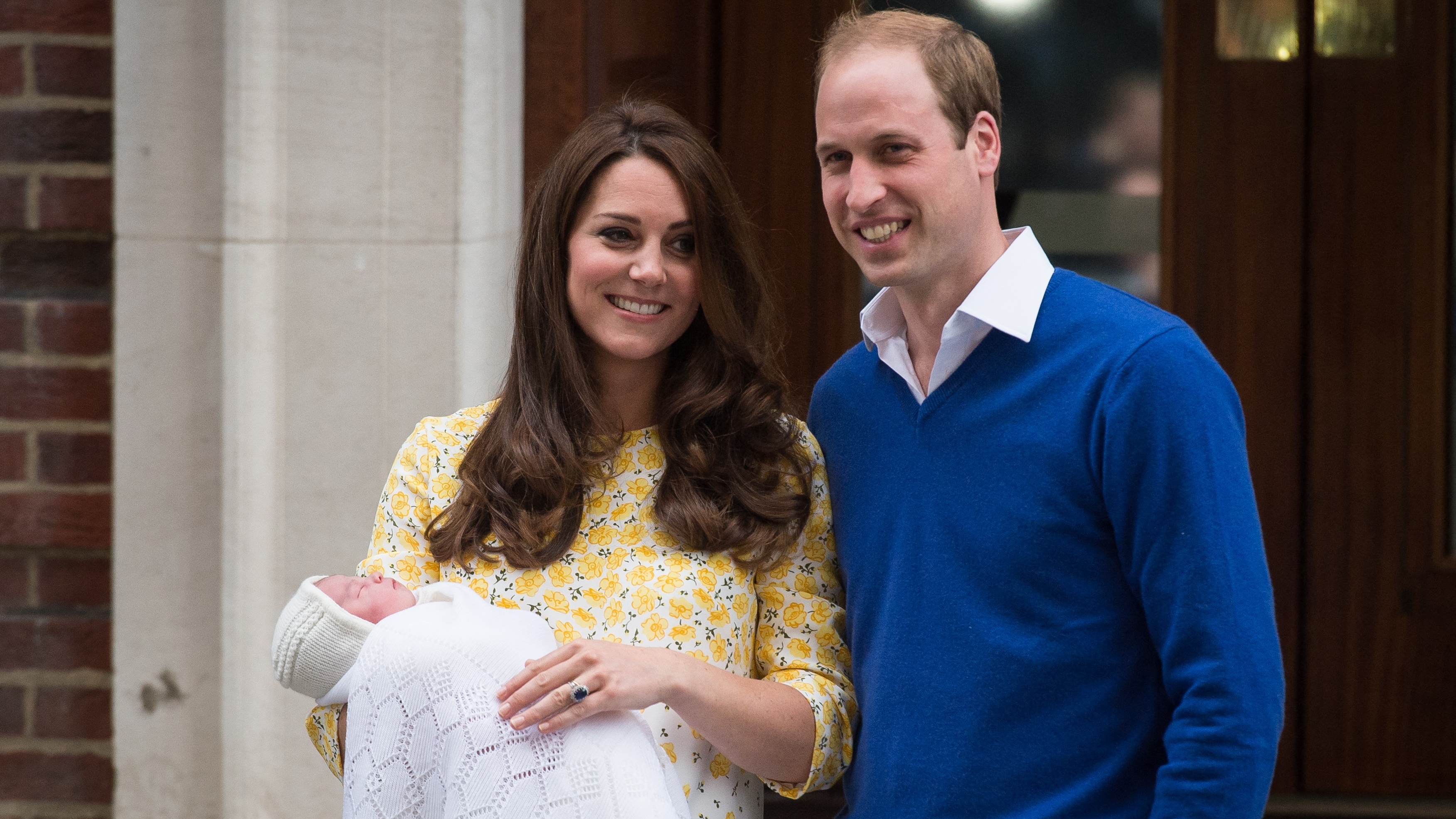 Prince William and Catherine, Princess of Wales stand holding Princess Charlotte outside the Lindo Wing at St Mary's Hospital in central London, on May 2, 2015