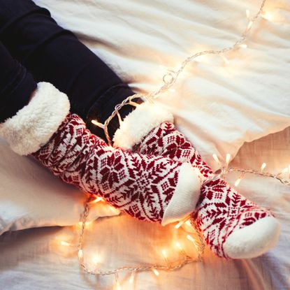 Young woman wearing fuzzy socks in her home in Christmas time