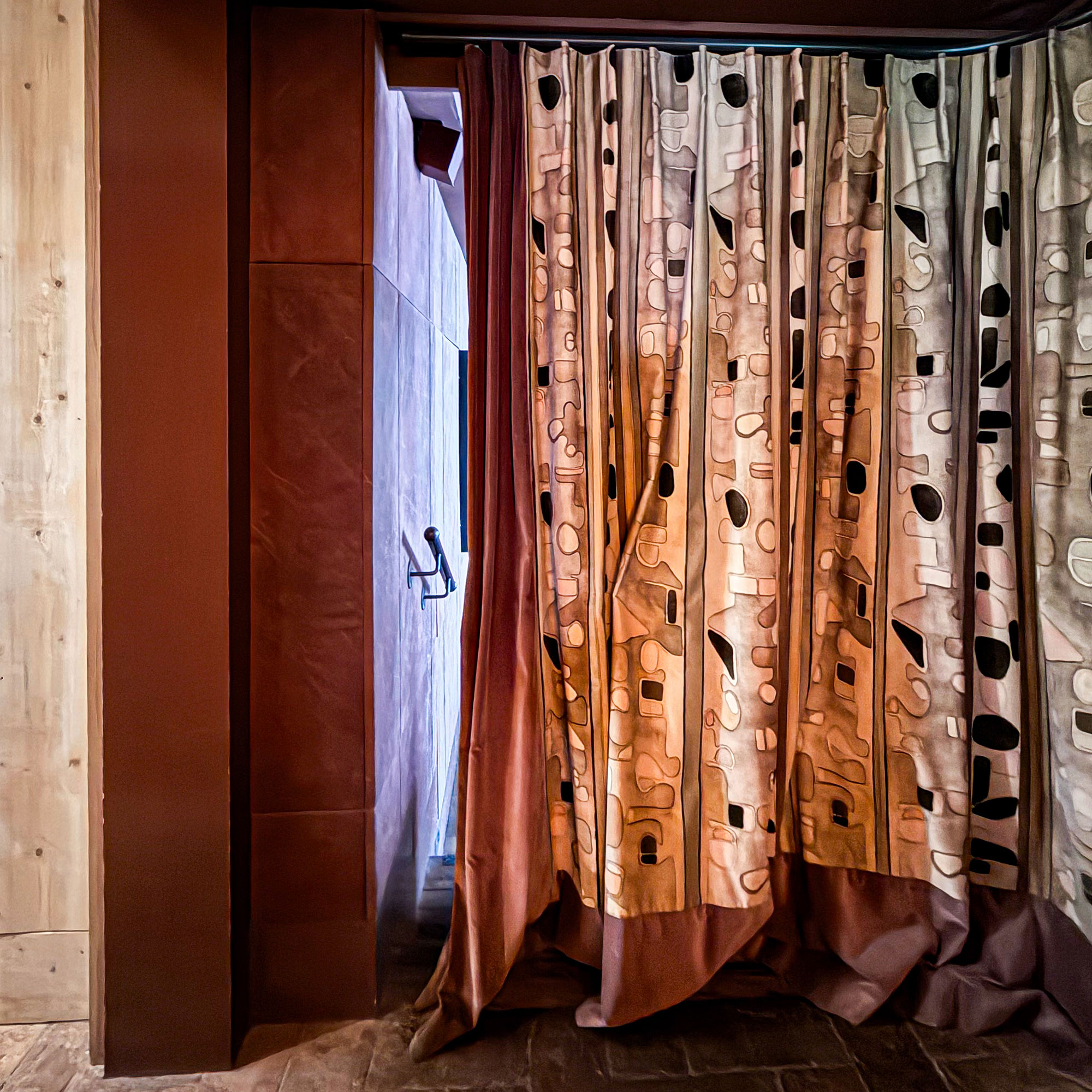 Patterned curtains hanging in a wooden hallway