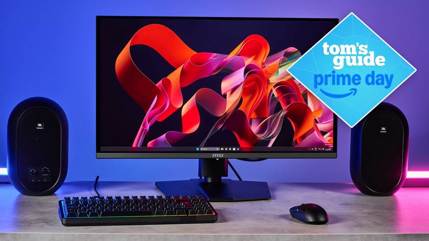 MSI MPG 272URX monitor on desk with speakers and keyboard with Tom&#039;s Guide Prime Day badge