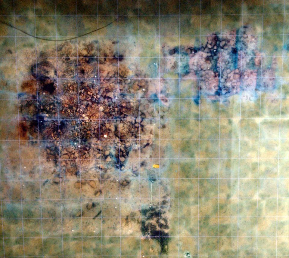 A mosaic image showing piles of stones on the seafloor