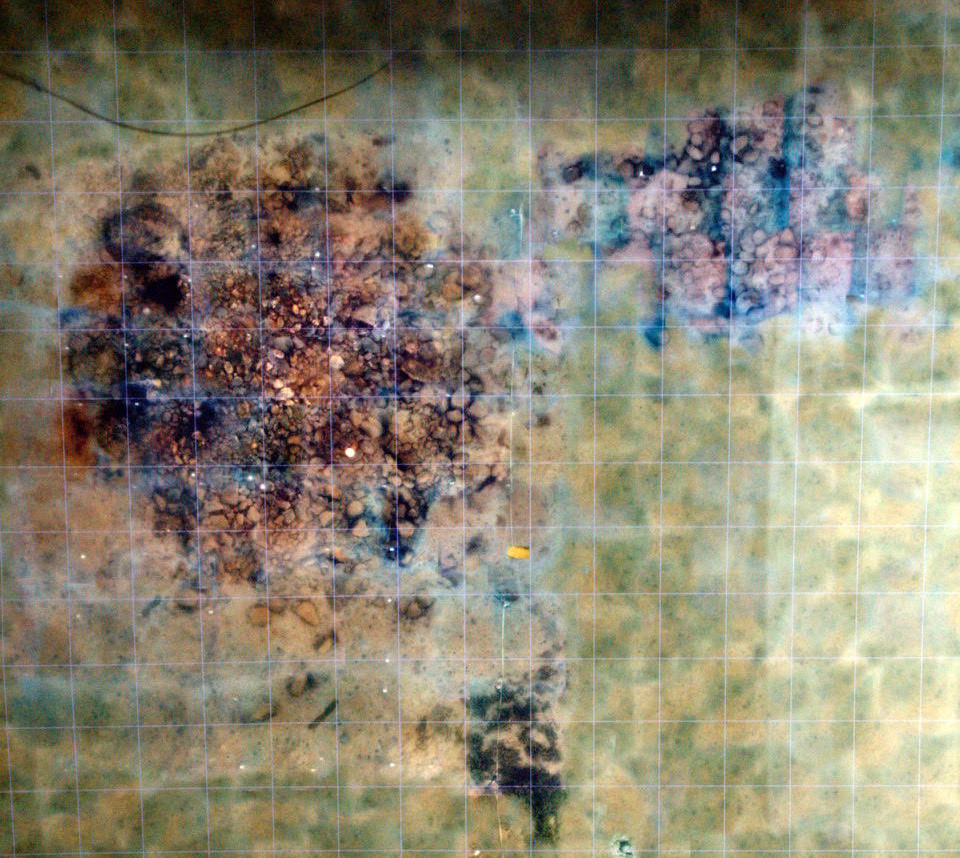 A mosaic image showing piles of stones on the seafloor