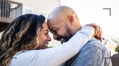 Couple laughing and hugging, standing up, representing the sex position for knee problems