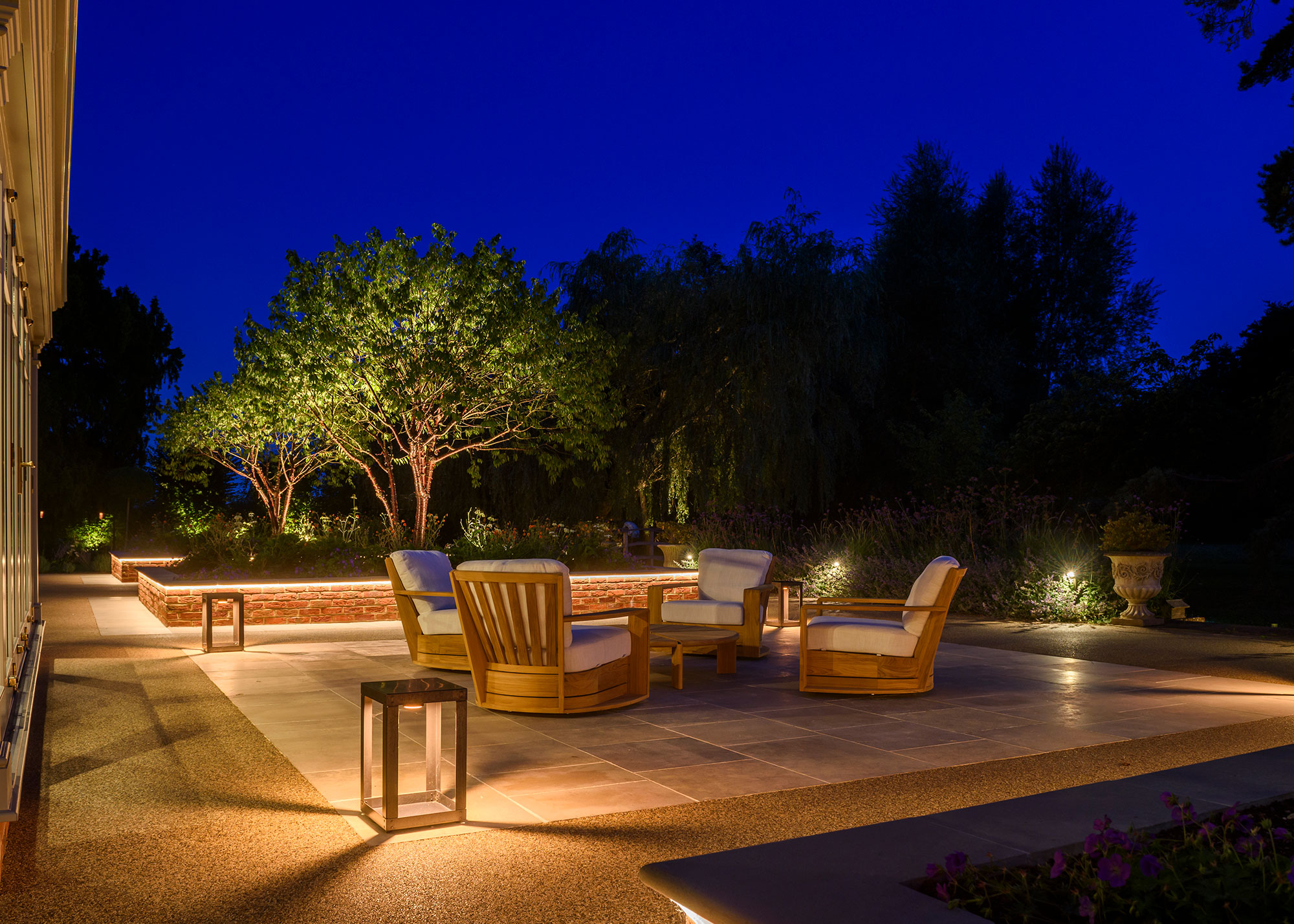 patio area with floor lanterns and uplit trees