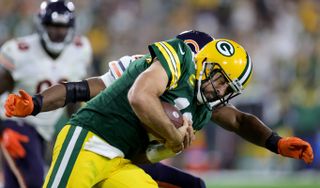 Aaron Rodgers #12 of the Green Bay Packers is tackled by Al-Quadin Muhammad #55 of the Chicago Bears during the fourth quarter at Lambeau Field on September 18, 2022 in Green Bay, Wisconsin.