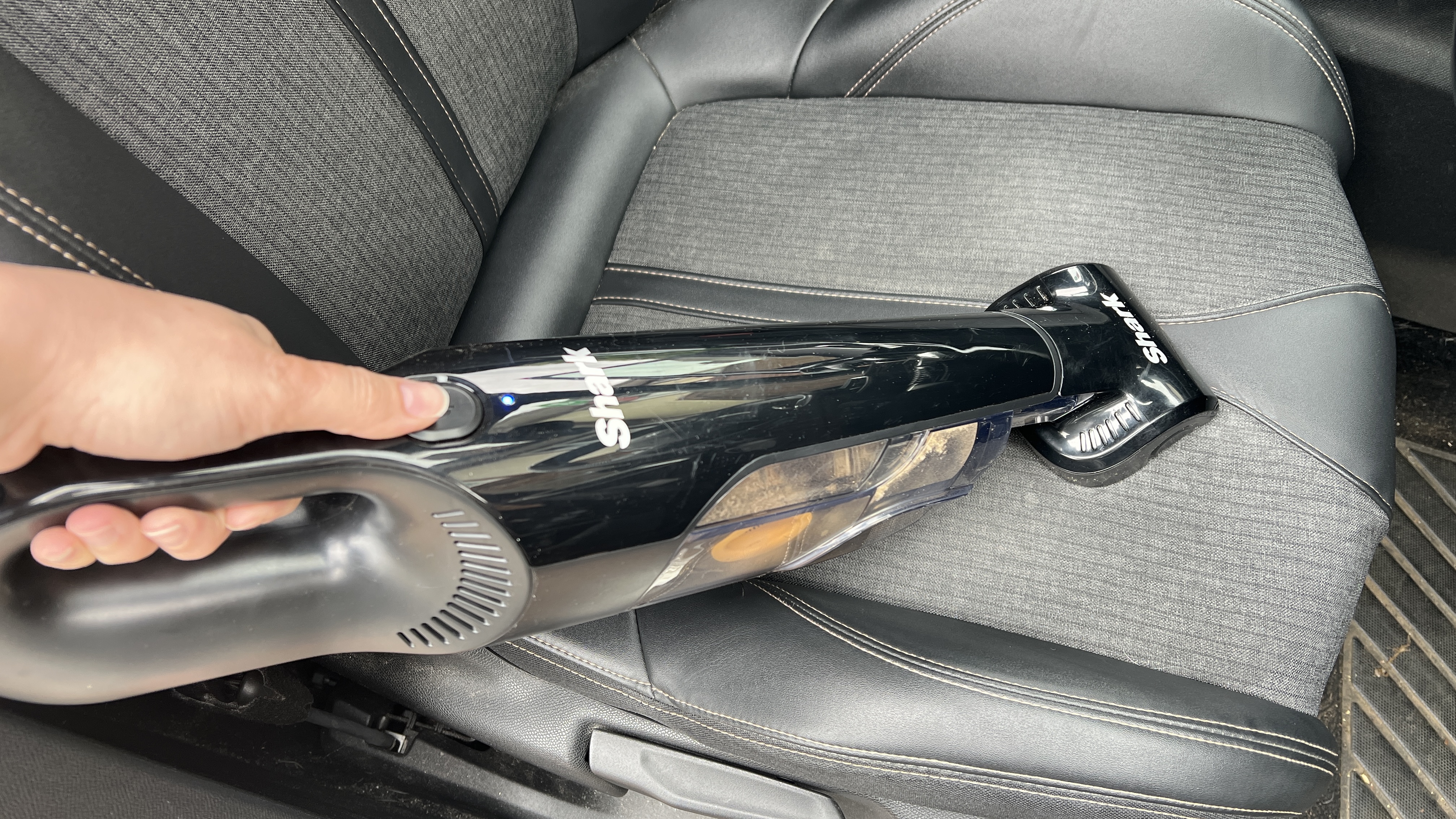 Penyedot debu genggam Shark UltraCyclone Pet Pro Plus digunakan di kursi mobil