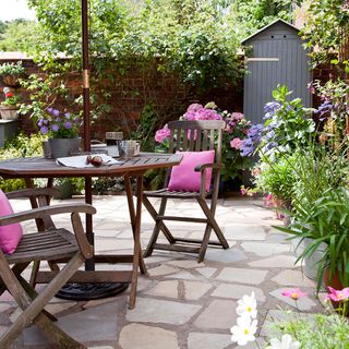 garden with wooden table and chairs and plants