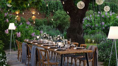 garden lighting ideas alfresco table dressed with lights set around festoon lights and pendants and solar powered floor lamps