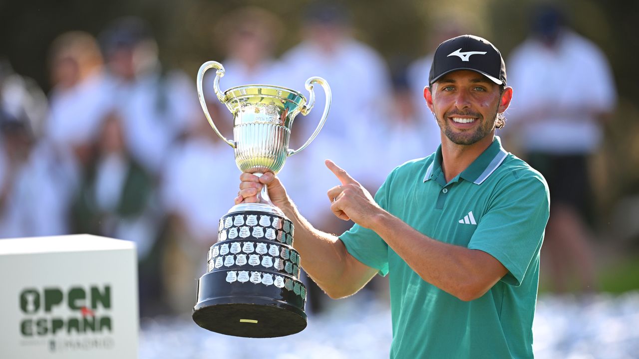 Marco Penge lifts the Spanish Open trophy with one hand and points to it with the other after winning in 2025