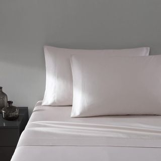 Vera Wang Queen Sheet Set on a bed against a gray wall.