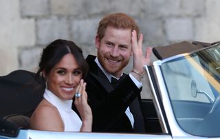 Britain's Prince Harry, Duke of Sussex, (R) and Meghan Markle, Duchess of Sussex, (L) leave Windsor Castle in Windsor on May 19, 2018 in an E-Type Jaguar after their wedding to attend an evening reception at Frogmore House. (Photo by Steve Parsons / POOL / AFP) (Photo credit should read STEVE PARSONS/AFP via Getty Images)