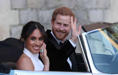 Britain's Prince Harry, Duke of Sussex, and Meghan Markle, Duchess of Sussex, leave Windsor Castle in Windsor on May 19, 2018 in an E-Type Jaguar after their wedding to attend an evening reception at Frogmore House. (Photo by Steve Parsons / POOL / AFP) (Photo credit should read STEVE PARSONS/AFP via Getty Images)