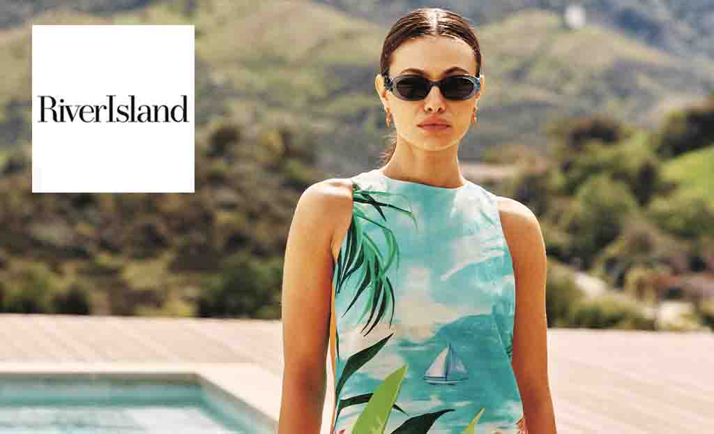 river island logo placed over an image of a woman posing in a tropical blue dress with sunglasses on