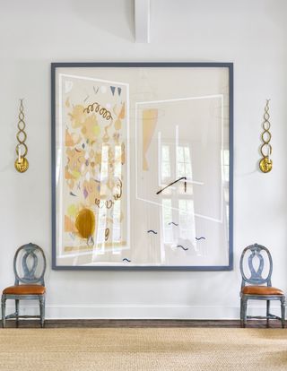 Entryway with oversized artwork and two chairs.