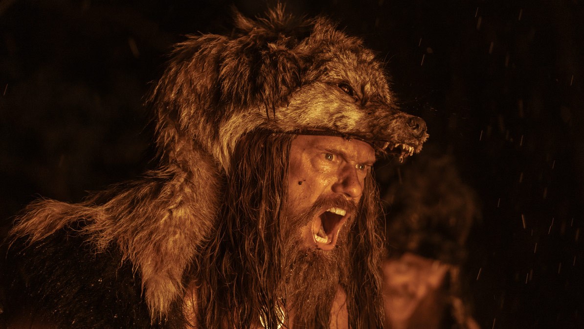 Alexander Skarsgard yelling while wearing a wolf skin in The Northman