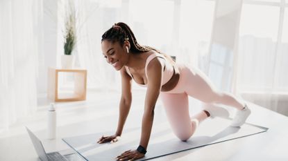 A woman doing a free home workout from her living room