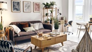 A modern apartment living room with framed wall art, sofa, coffee table, styled by Homesense