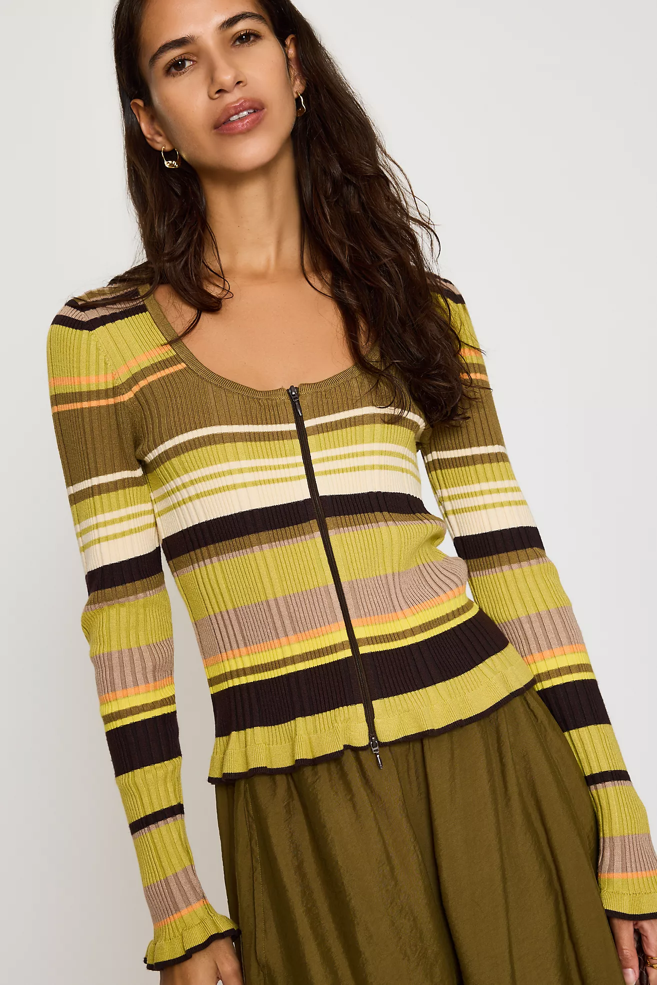 A model wearing a green and brown striped Anthropologie cardigan.