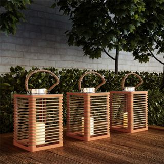 Three outdoor lanterns on a wooden deck
