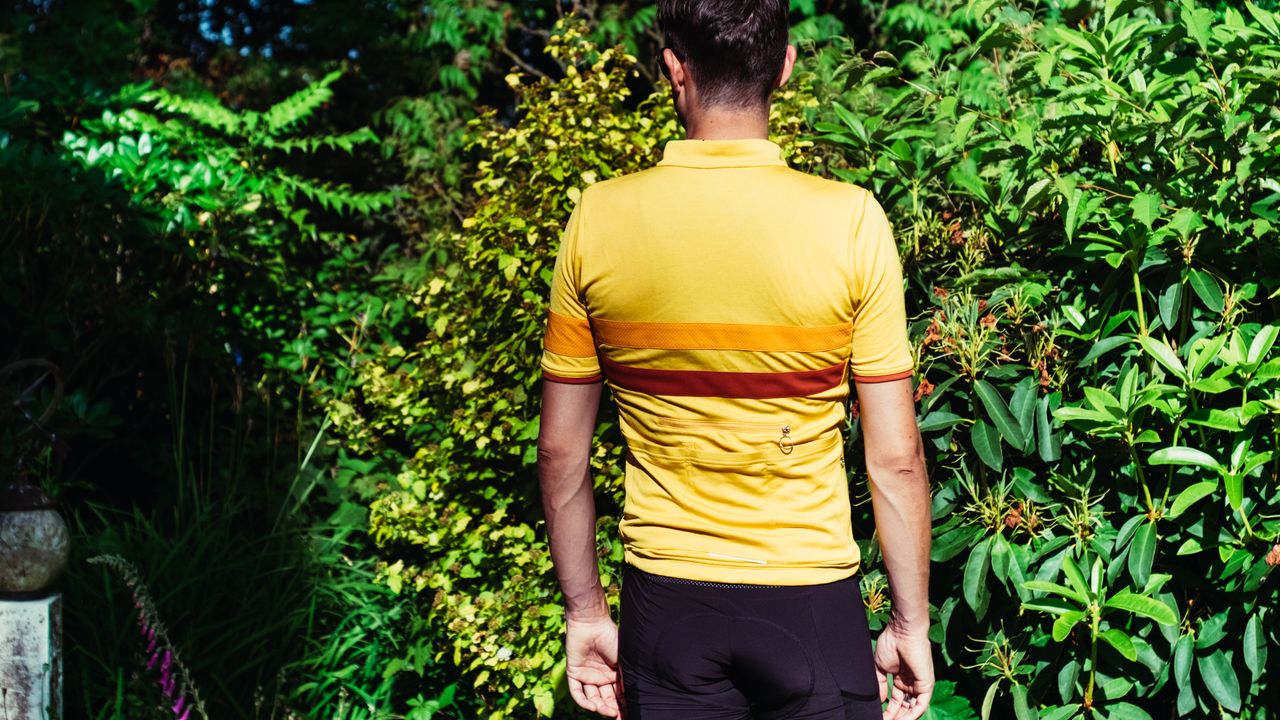 The rear of a white man wearing a yellow jersey