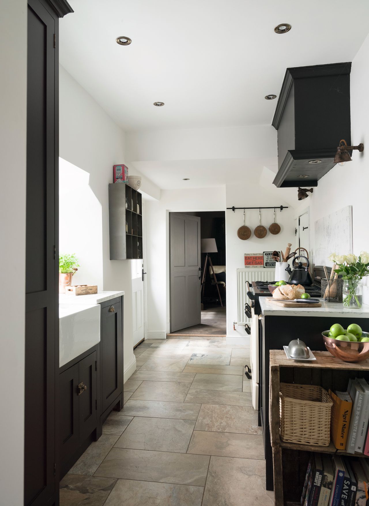 black galley kitchen in cottage with tiled floor