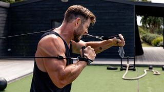 a photo of Chris Hemsworth using a resistance band