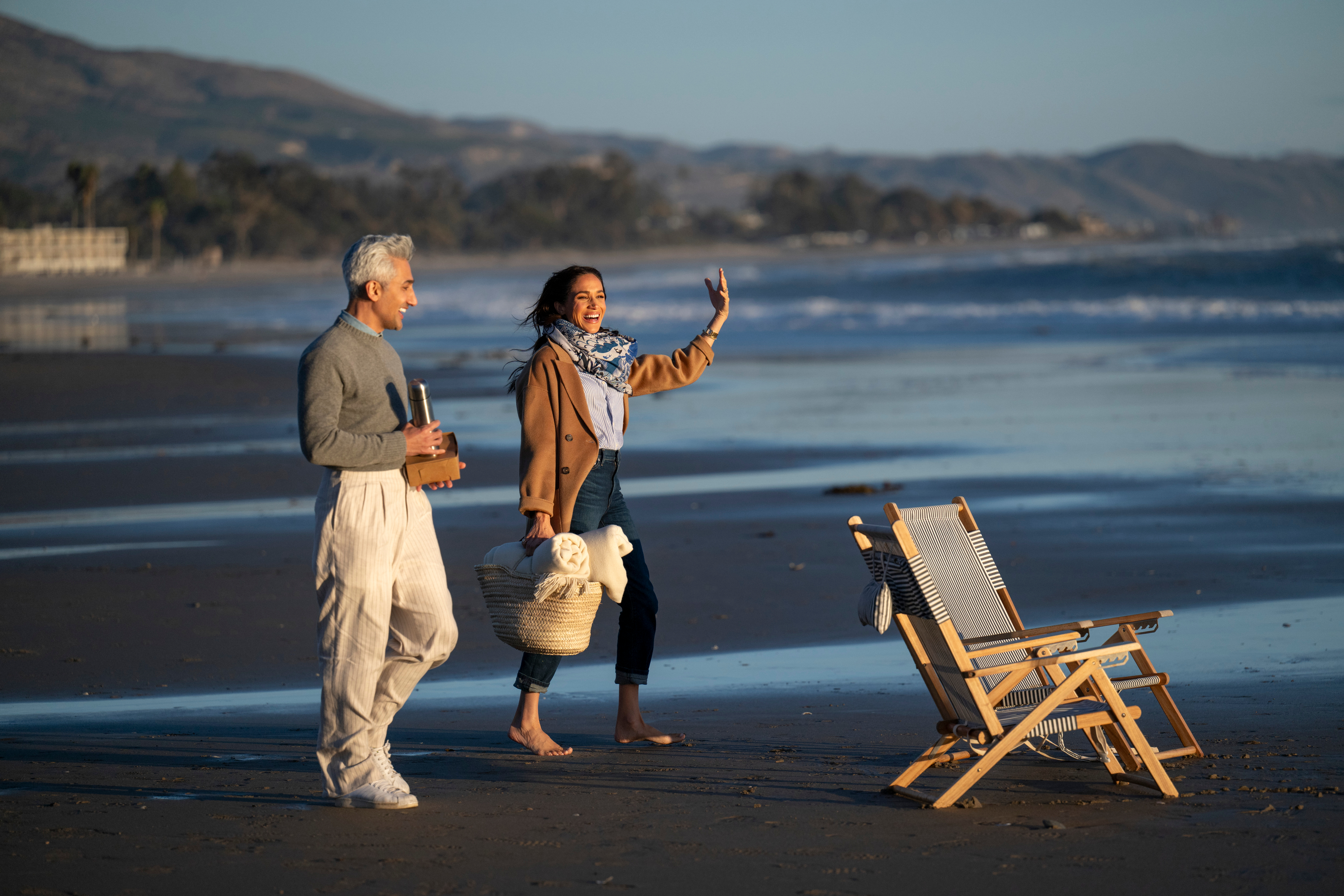 Tan France and Meghan Markle walking on the beach