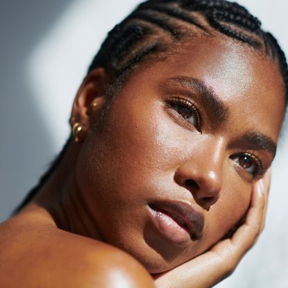 black woman with glowing skin against a sunny backdrop