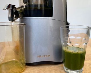 Green vegetable juice in glass made using the Hurom H-AA slow juicer appliance
