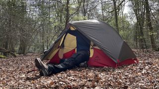 Man pitching MSR Hubba NX tent in the woods