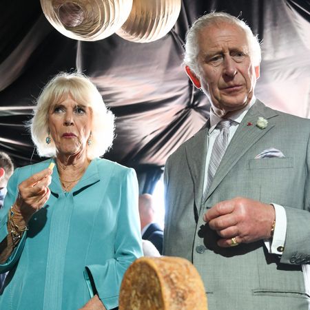 Queen Camilla eating food, King Charles looking at food