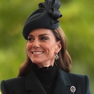 Princess Kate wearing a green hat and coat and smiling