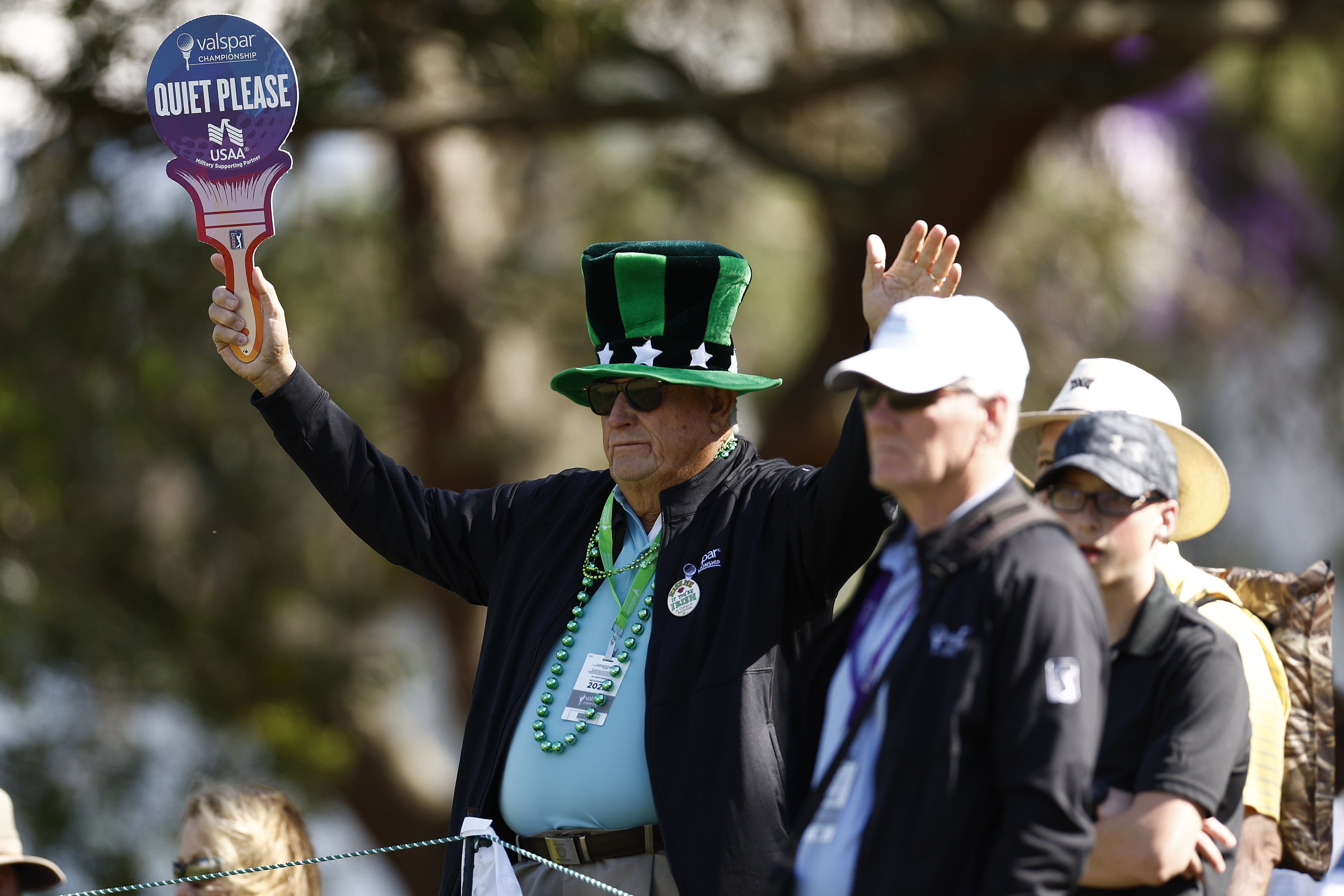 A tournament volunteer holds up a &quot;quiet please&quot; sign at the 2024 Valspar Championship