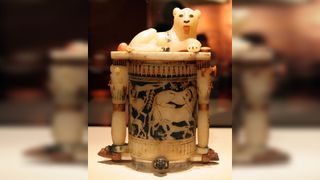 This jar, found in Tutankhamun's tomb, has a lion at top. The motifs at the bottom may represent Egypt's enemies in Nubia and western Asia and may represent triumph over them. The jar may have been used to hold cosmetics.