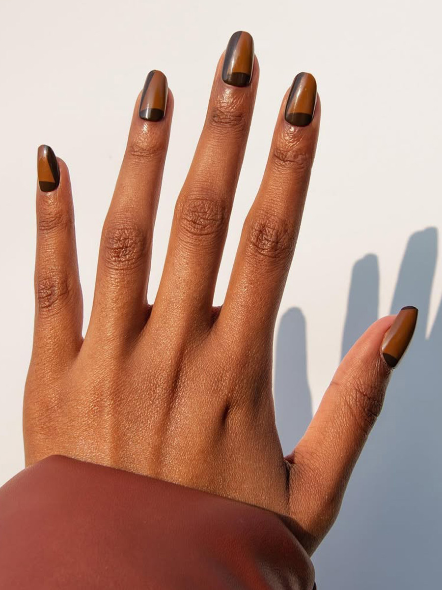 Graphic nail art in shades of brown on Hannah Harris.